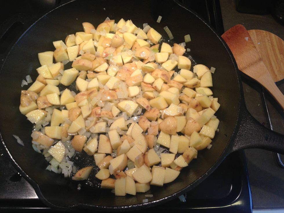 Potatoes go in. Turn the heat down a bit. Cook these until they're tender.