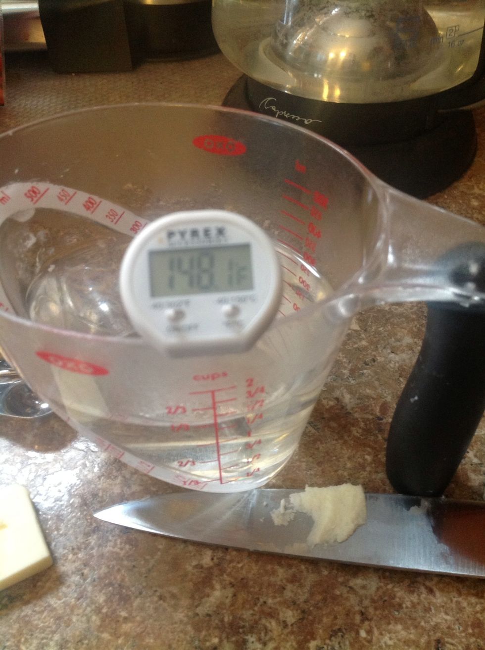 Pour 1 1/4 cups PLUS 2 TBLSP of really hot water into your measuring cup. Add 2 tbsp of soft butter. As you can see this water is TOO hot. Let it cool until it is between 120-130 degrees. Stir to cool