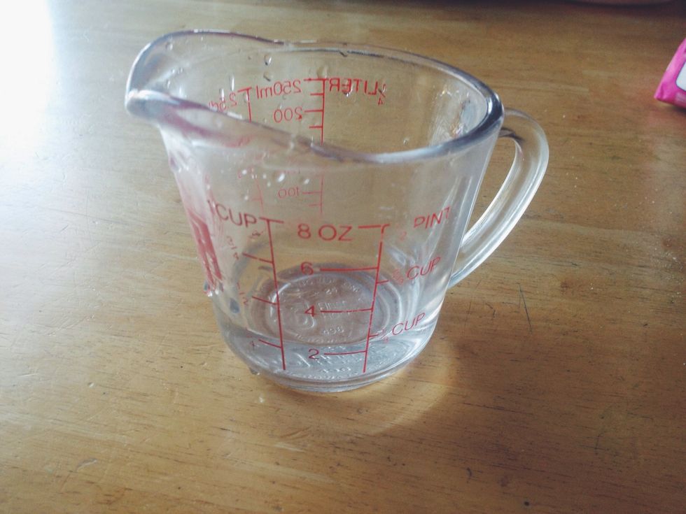 Pour 1/4 cup of water into a measuring cup.