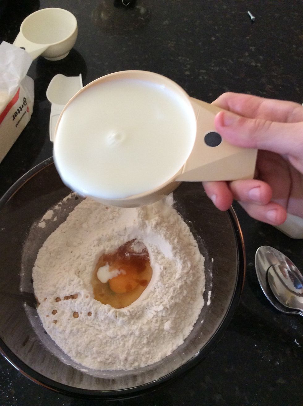 Pour 1 cup of milk into the pancake mixture.