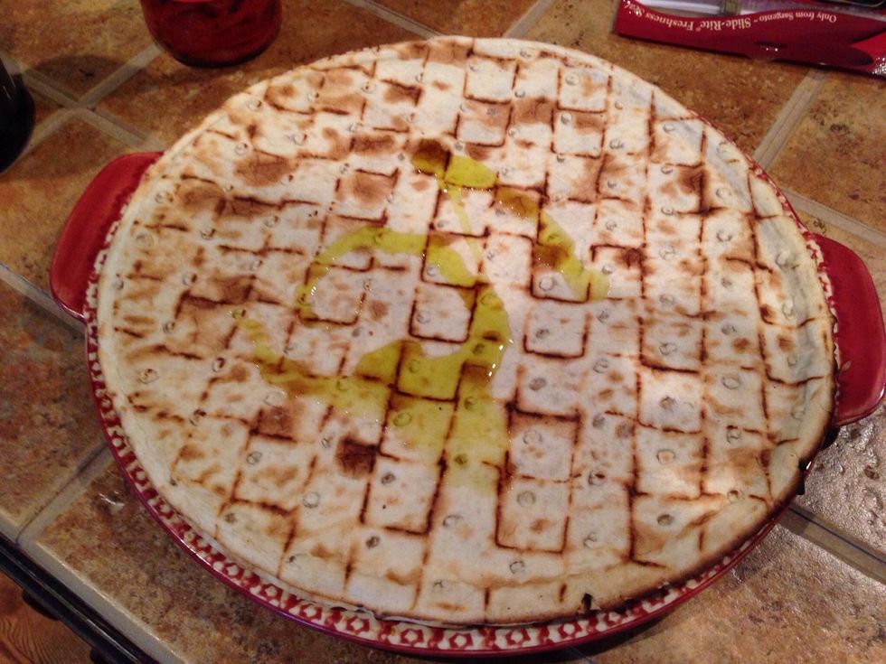 Pour 1 tbls. olive oil onto crust and smear it to the edges.