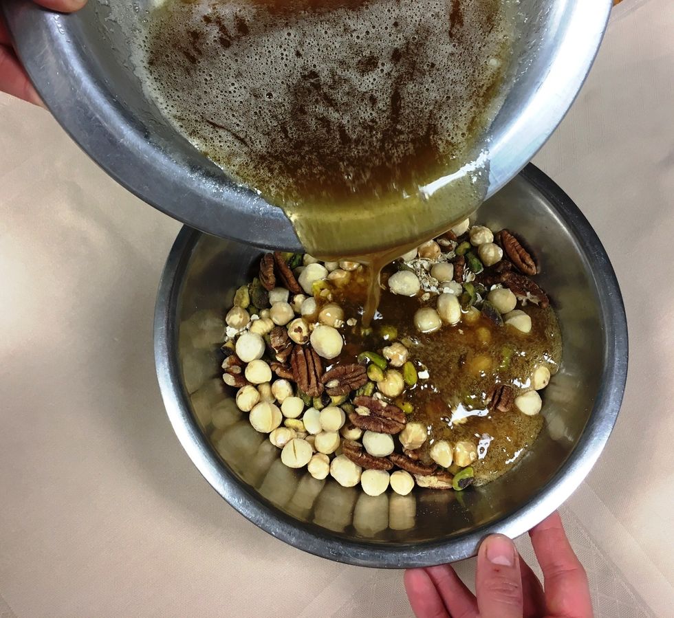 Pour 60% of the liquid mixture over the nuts, combine well.