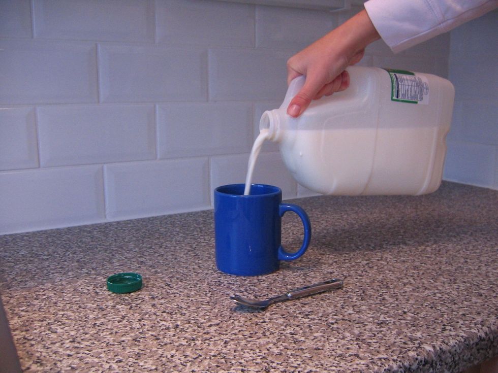 Pour a small amount of milk into a mug.