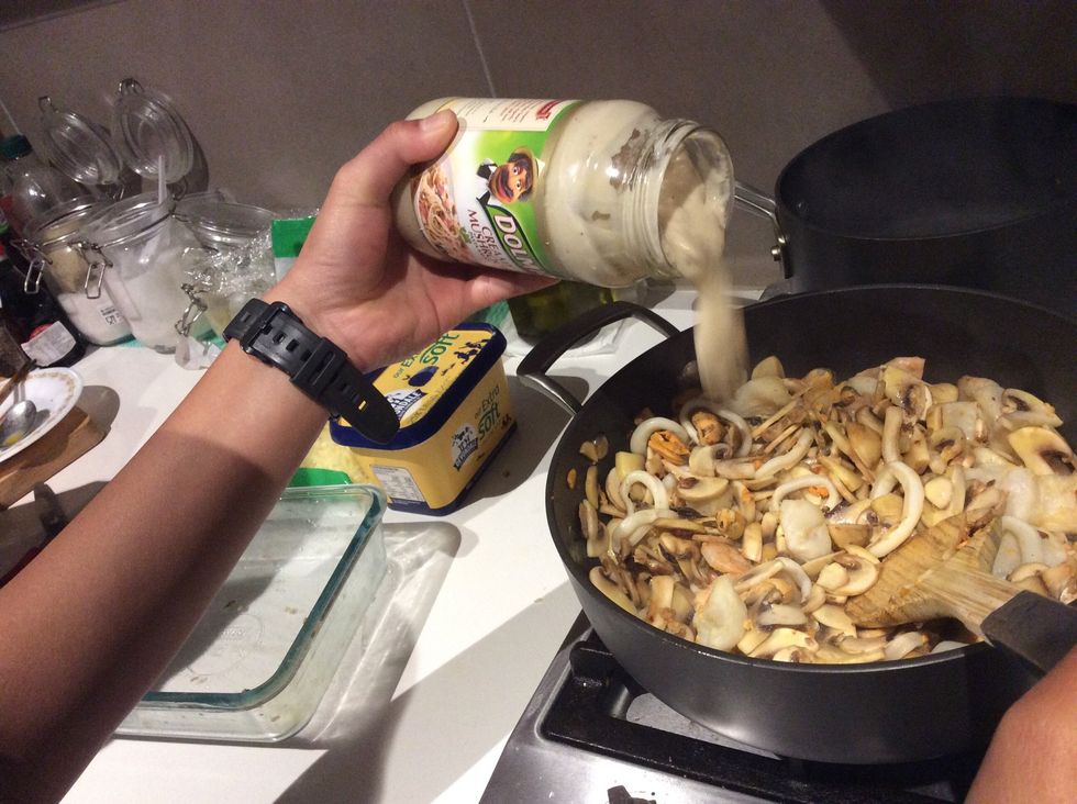 Pour a whole jar of creamy mushroom sauce into the pot and mix for 3-4 minutes.