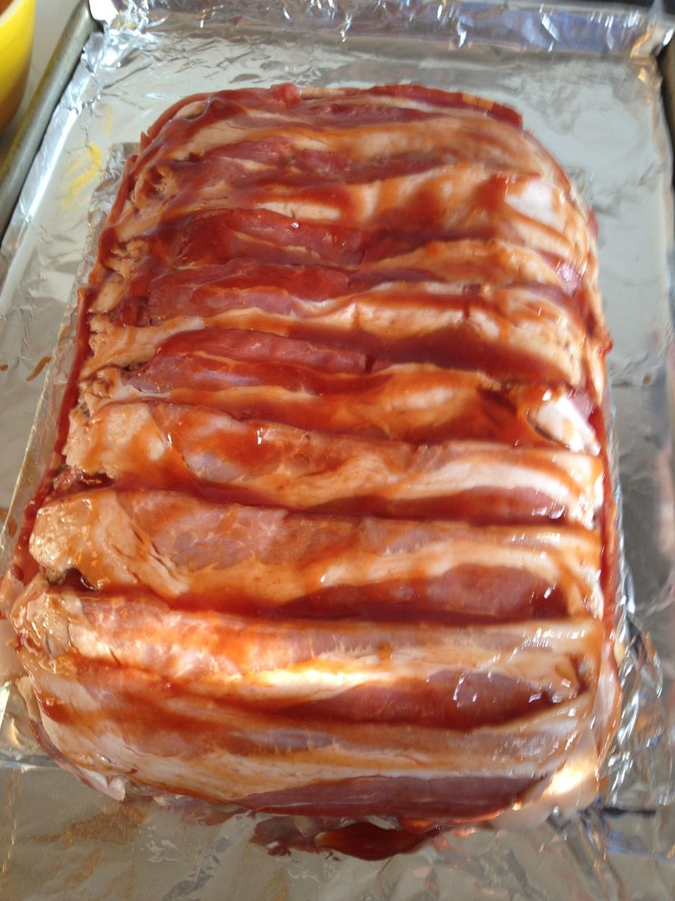 Pour about one-third of the sauce you just made over the top of meatloaf. Using your hands spread it to coat the meatloaf evenly. Place it in the oven and bake for 45 minutes.