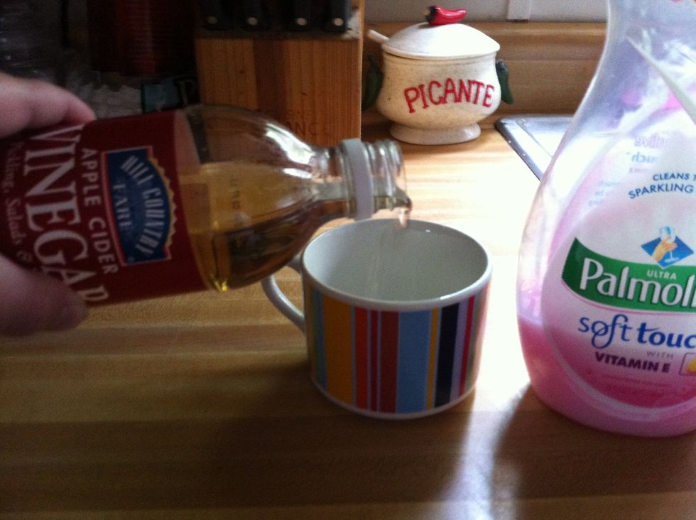 Pour apple cider vinegar until the cup or bowl is half full.
