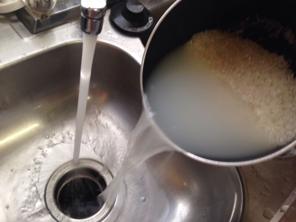 Pour as much water out without spilling the rice