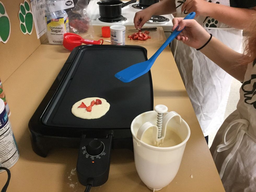 Pour batter onto pre -heated griddle and top with strawberries. Cook until golden brown.
