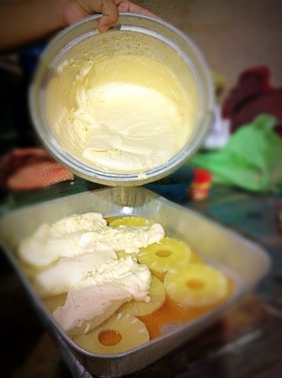 Pour butter evenly over the pineapple in the cake tray...