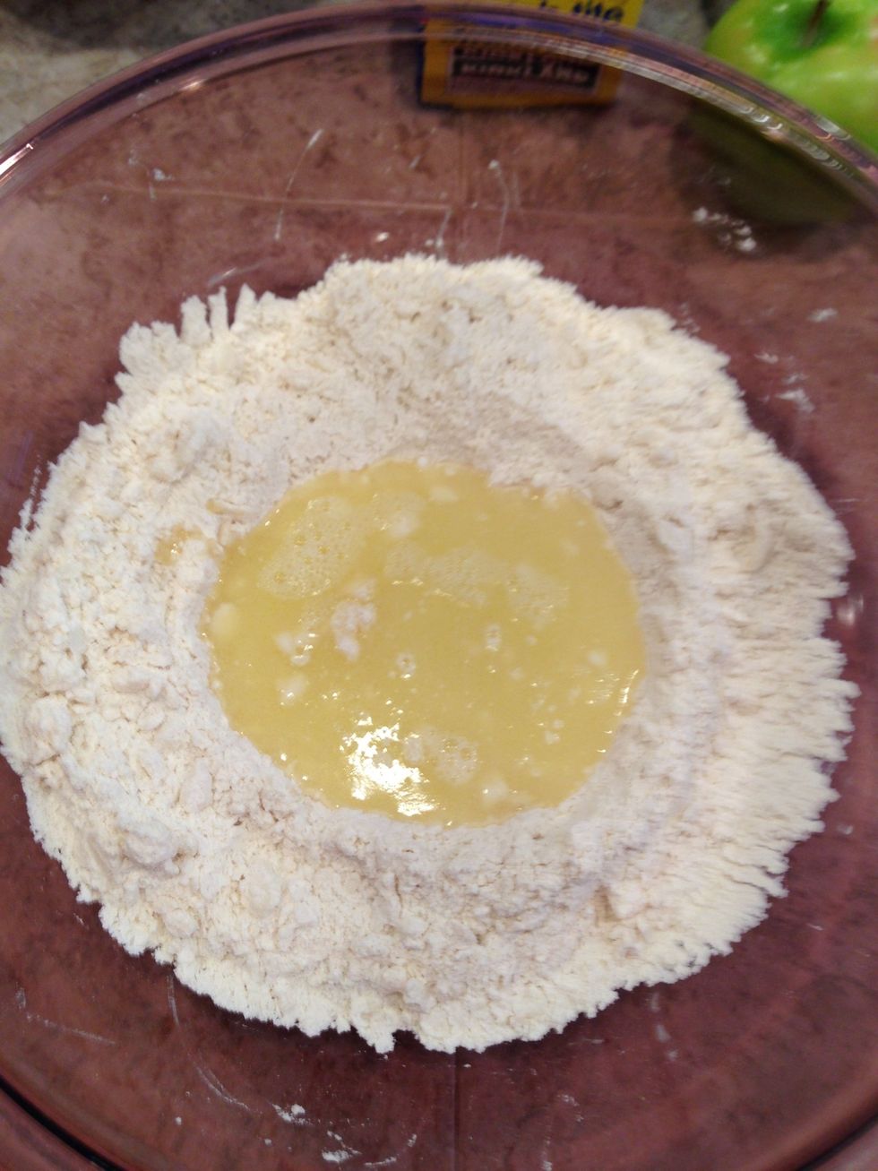 Pour butter mixture into center of well.