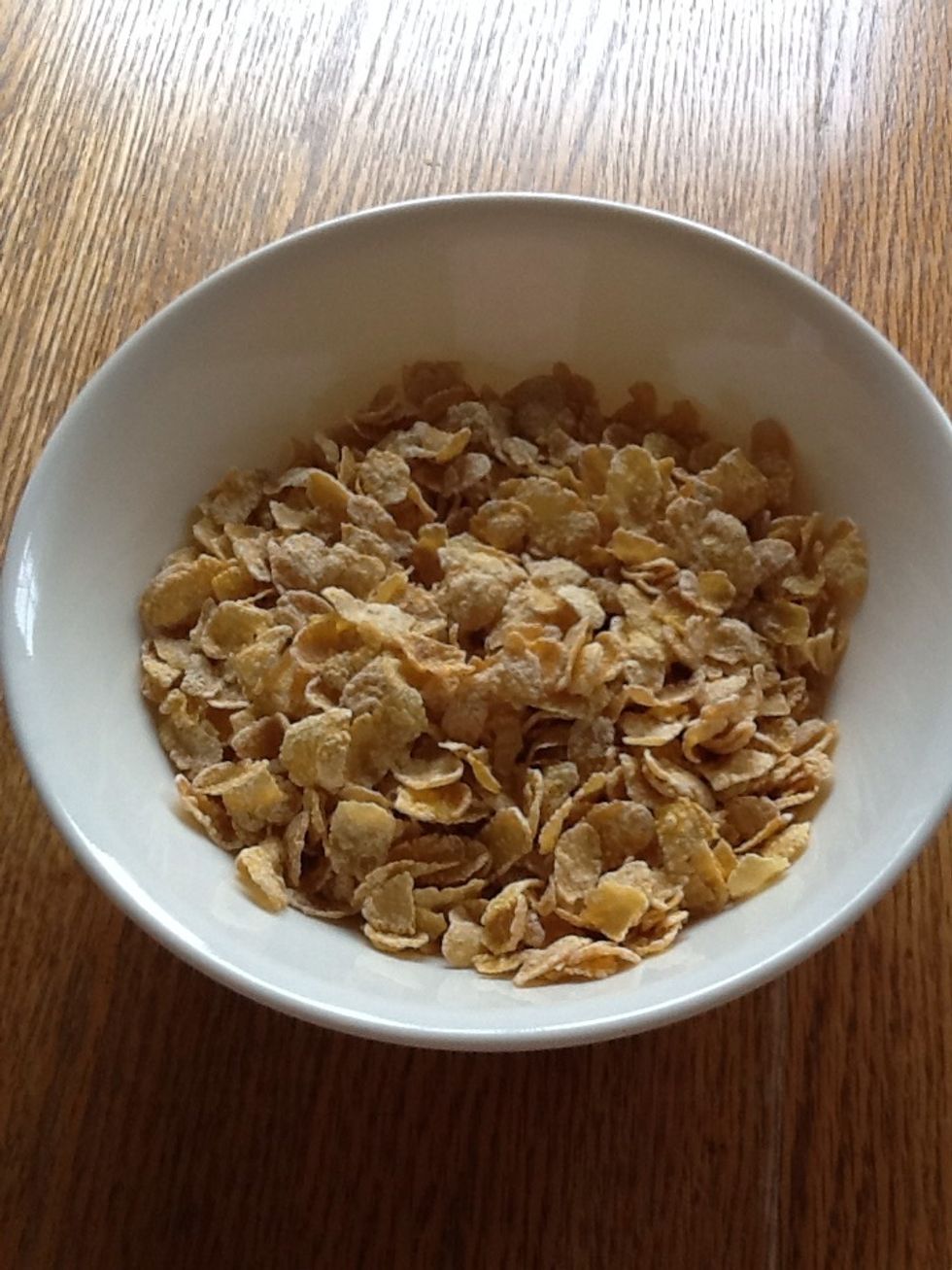 Pour cornflakes in a bowl.