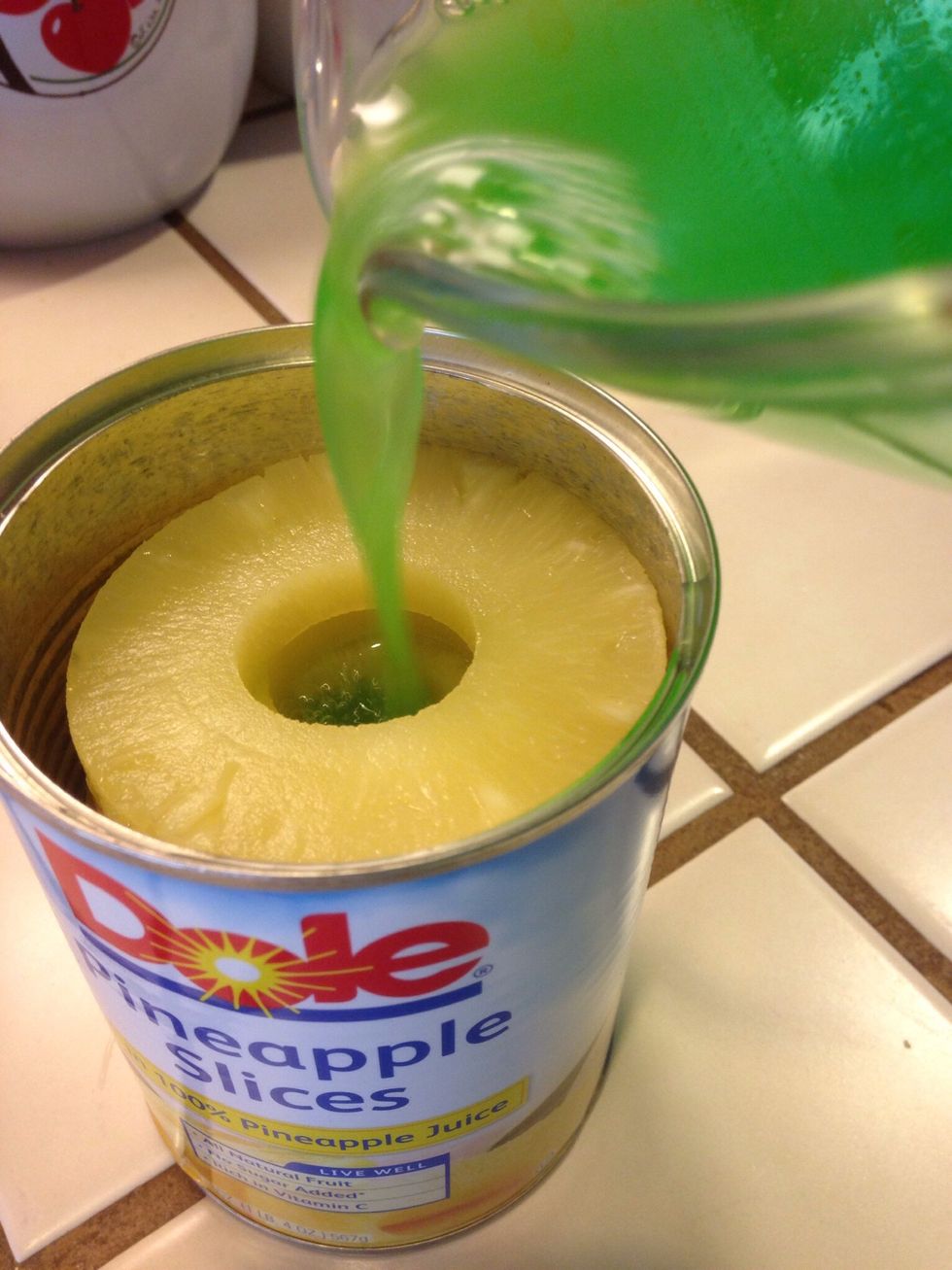 Pour dissolved liquid jello into can with pineapple.