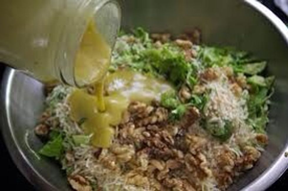 Pour dressing over Brussels sprouts and onions. Using tongs mix everything together.