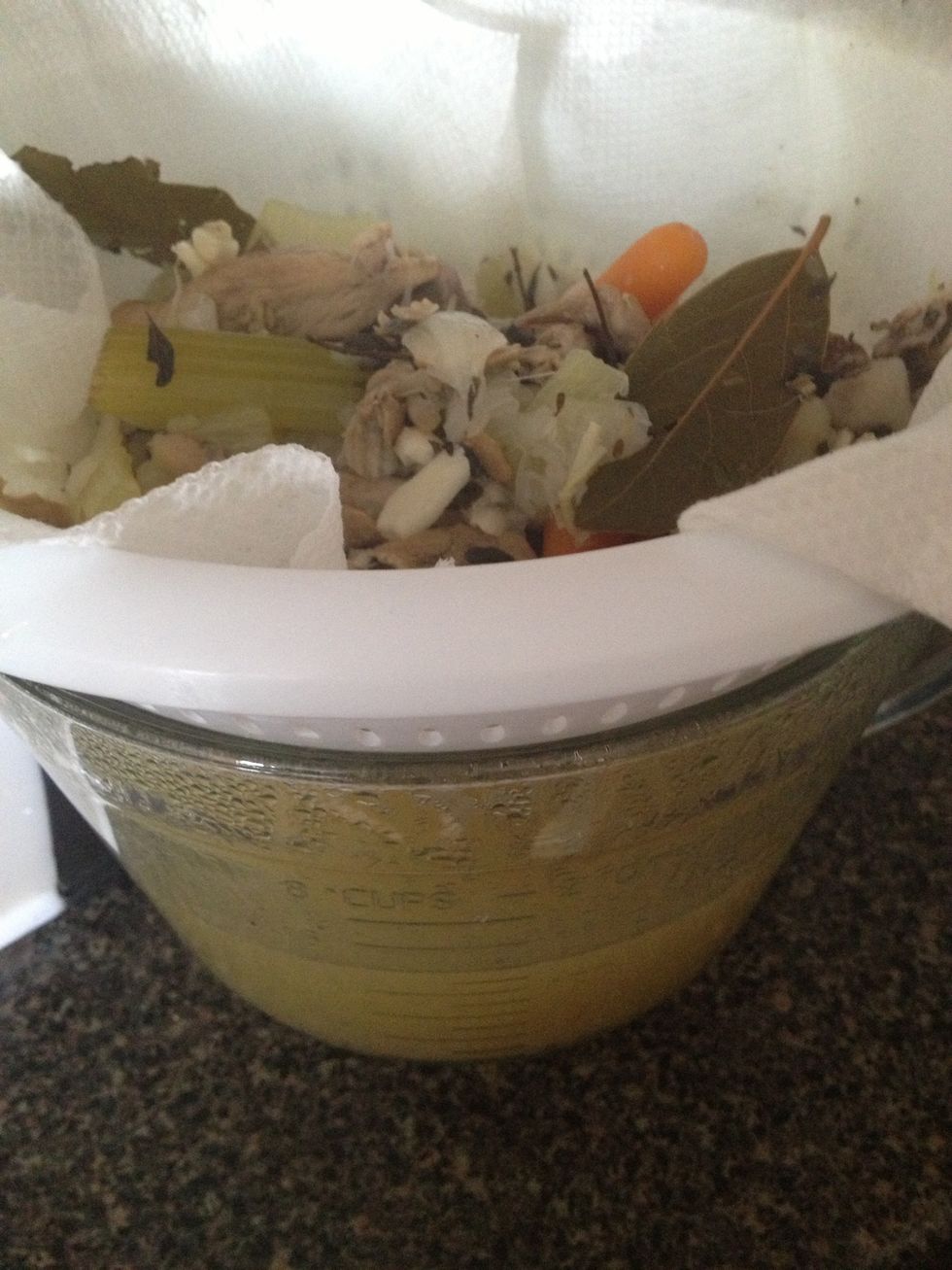 Pour everything into strainer to separate the vegetables, bones and herbs out of the broth. Once broth is settled, skim off any fat that's floating on top.