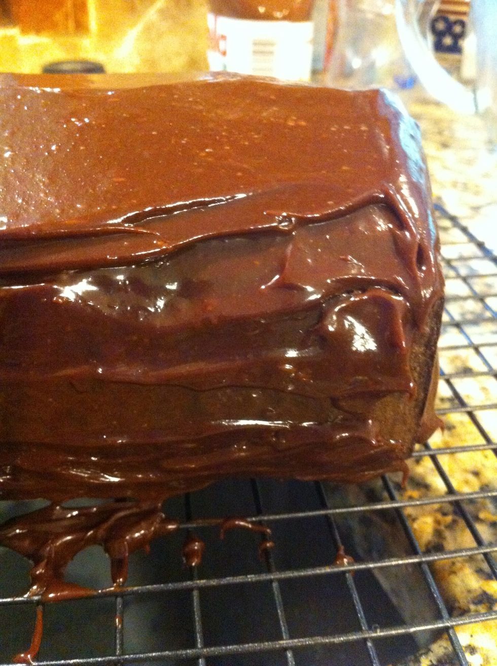 Pour ganache over and use a small off set spatula to spread on sides. Let this get cold in fridge for about 30 before you move it to platter