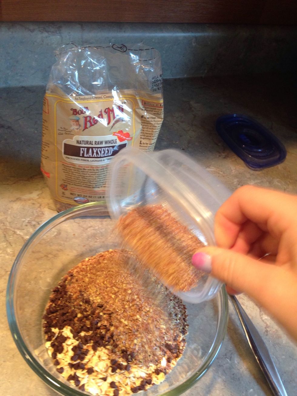 Pour half a cup of the ground flaxseed into the bowl.
