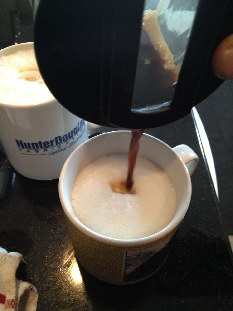 Pour half espresso into each cup of steamed milk