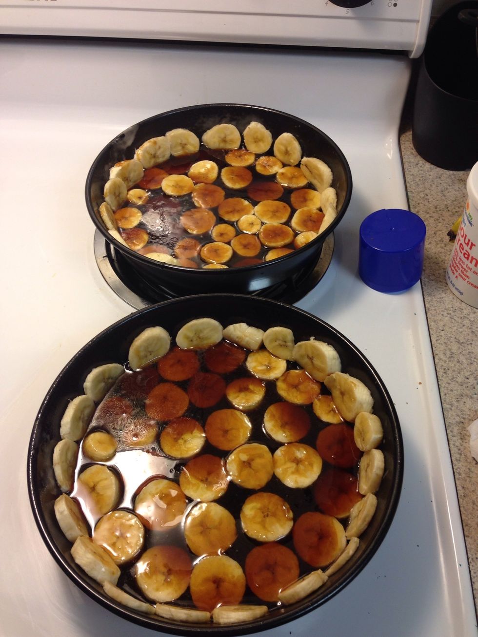 Pour half of the brown sugar mixture into each of the 2 round cake pans over the bananas.