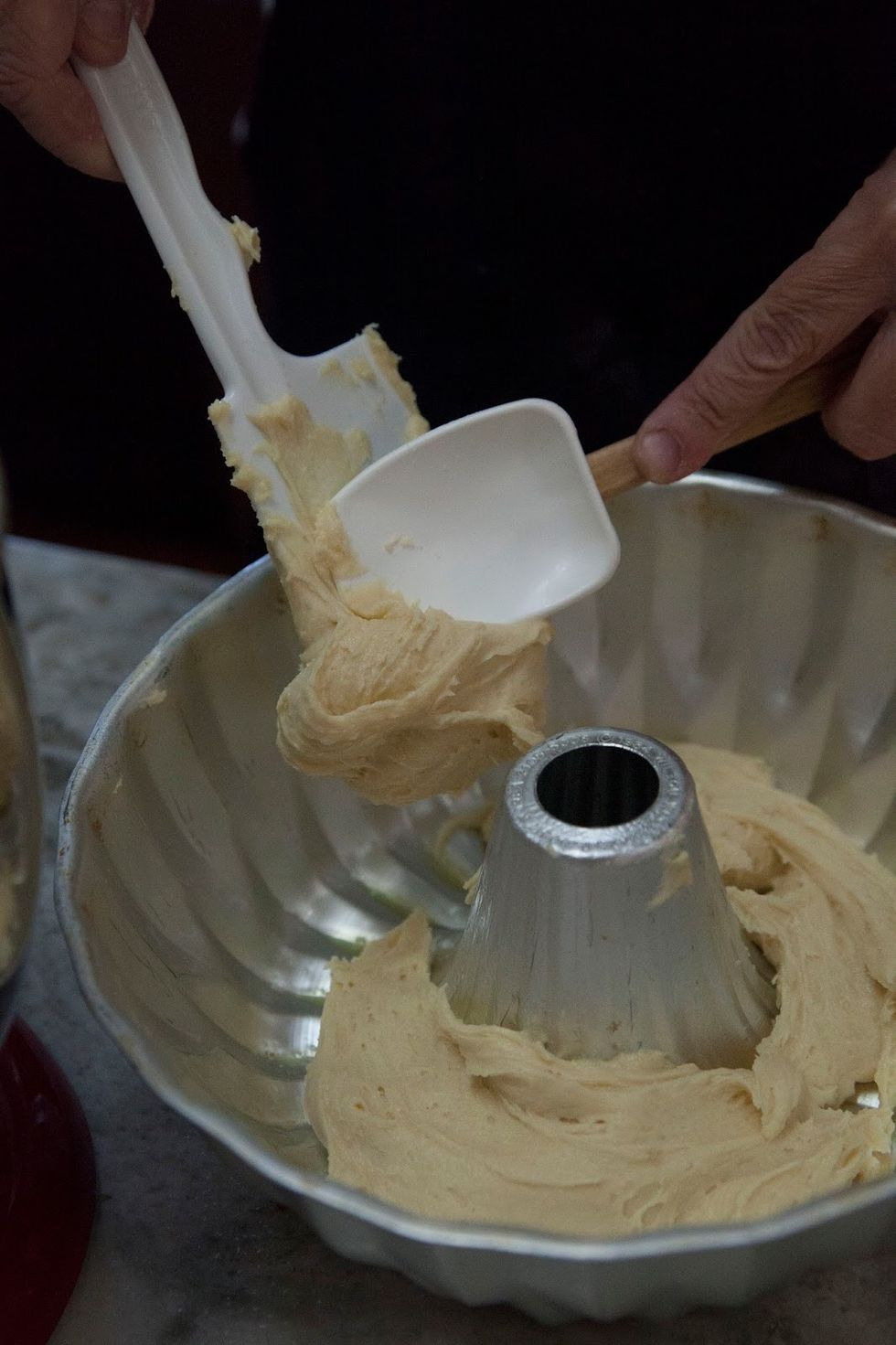 Pour half the batter into the greased bundt pan.