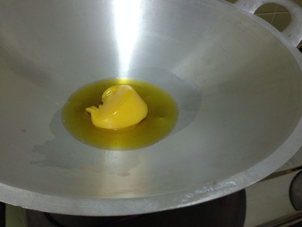 Pour half the ghee into the wok.