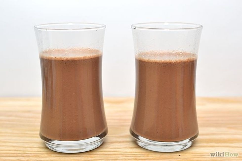 Pour hot chocolate into mugs.