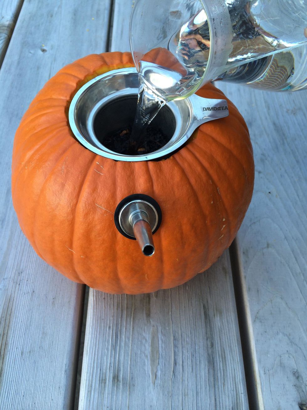 Pour hot water over the tea and into your pumpkin teapot, filling it up until the tea is fully covered by the water.