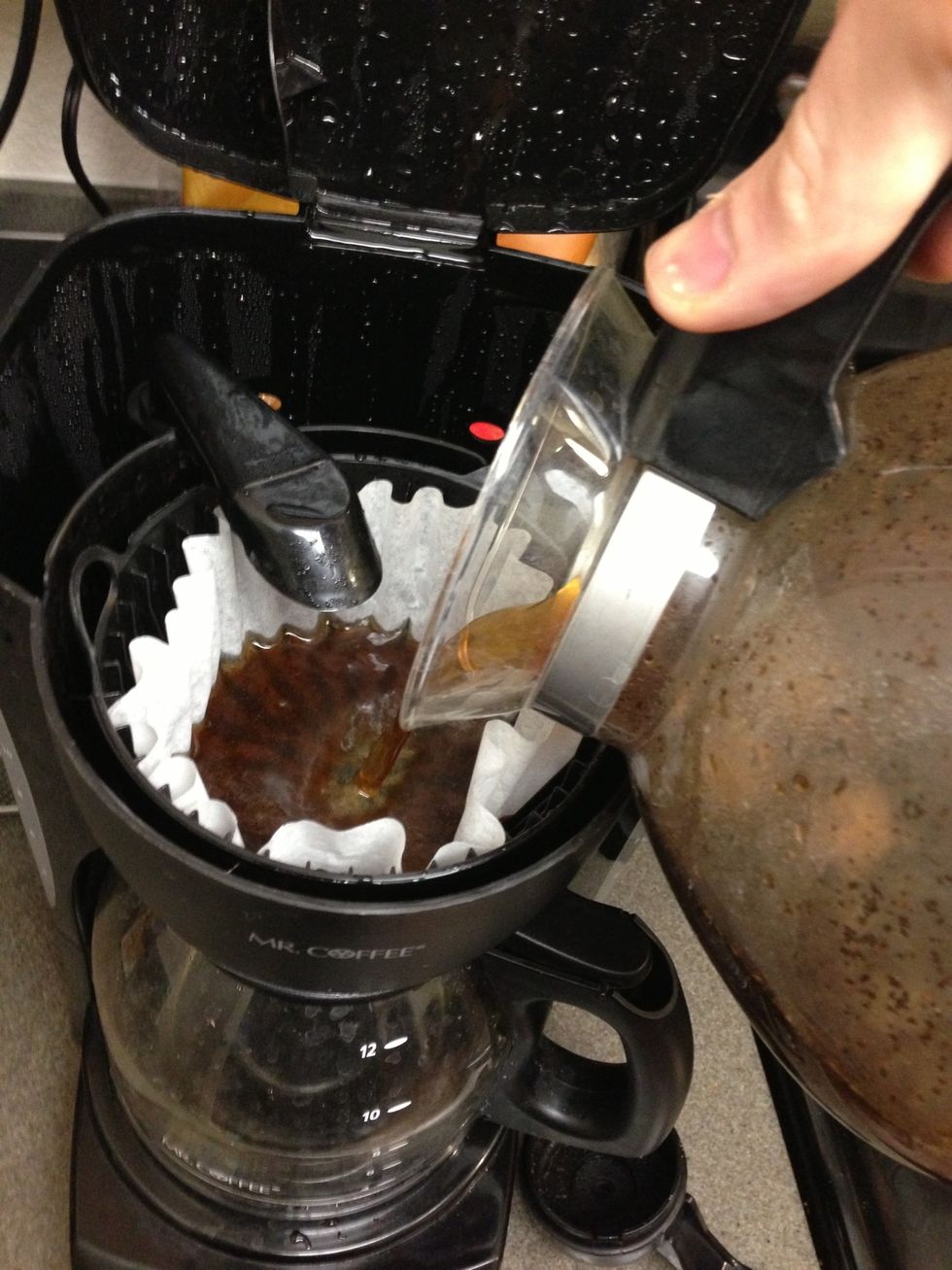 Pour iced coffee mixture into the filter area to strain out all of the coffee grinds.
