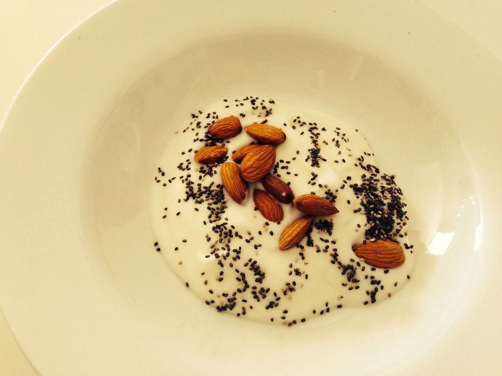 Pour in about 200 grams yoghurt (or as much as you want to eat). Sprinkle over Chia seeds and a palm full of almonds.
