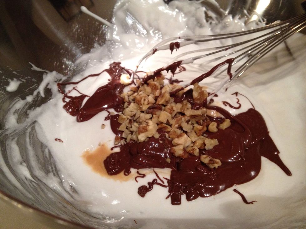 Pour in melted chocolate, chopped walnuts, and vanilla extract into whisked egg whites - sugar mixture.