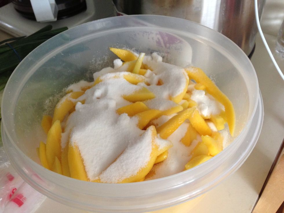 Pour in sugar. Mix thoroughly and let it sit for another 2 hours. You'll see that the salt has drawn out the liquid from the fruit.