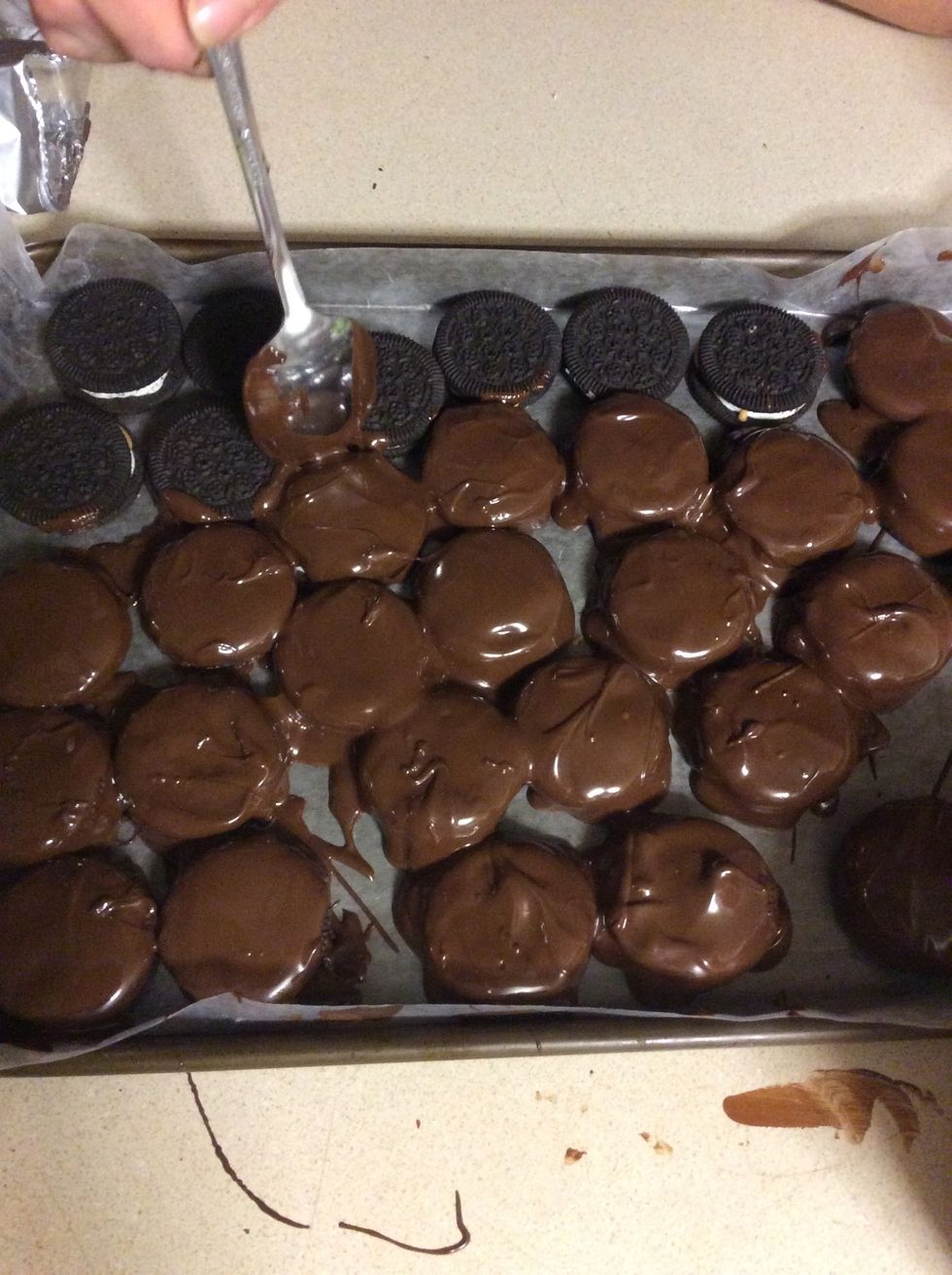 Pour melted chocolate over the Oreo cookies.