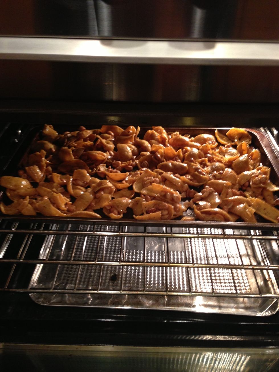 Pour melted mixture over dry goods and stir until everything is coated. But on a greased cookie sheet and the into a 250degree oven. Stir every 15 minutes for 30-45 (until dark golden brown).
