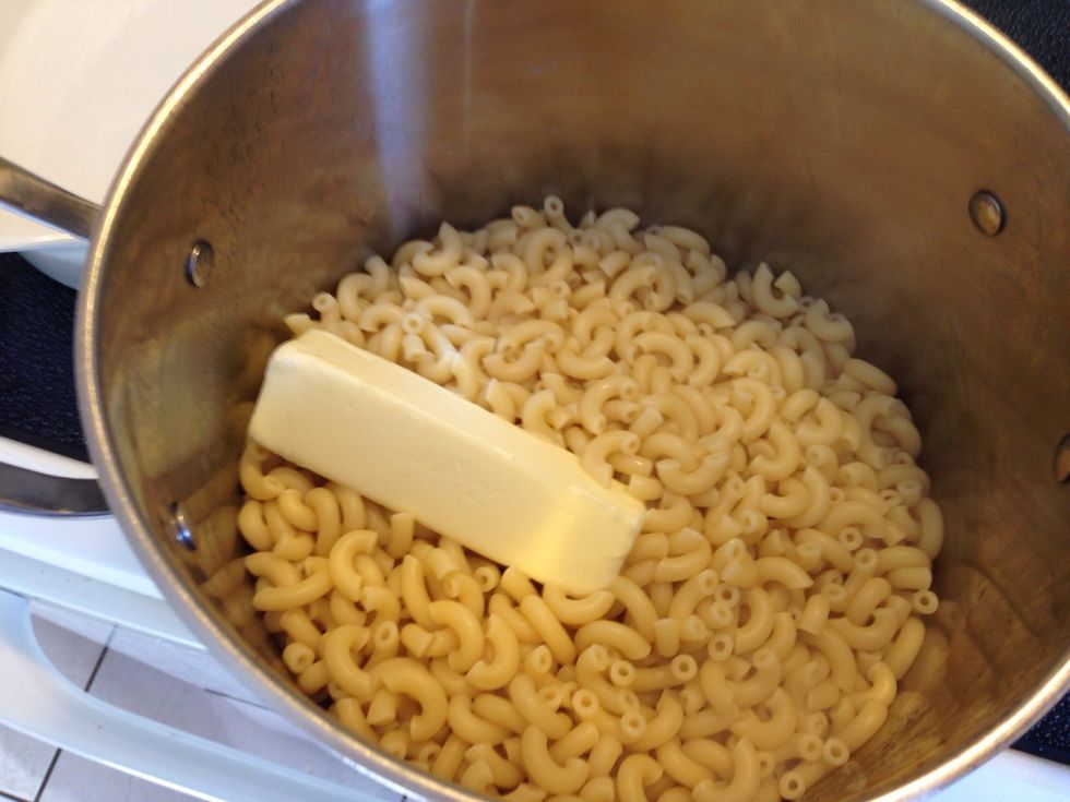 Pour noodles back into pot! Do not place noodles on the burner yet! Place the stick of butter into the pot! Allow to milk! You may put the pot back on the burner very low temperature