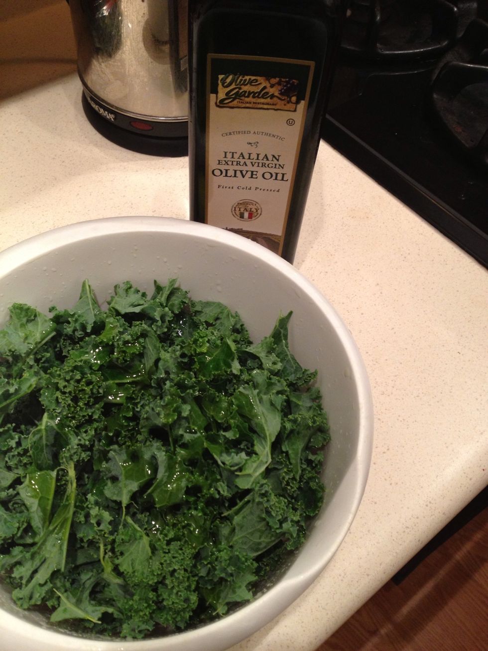 Pour olive oil into bowl and mix around until all leaves are coated. Don't use too much or kale will eat soggy