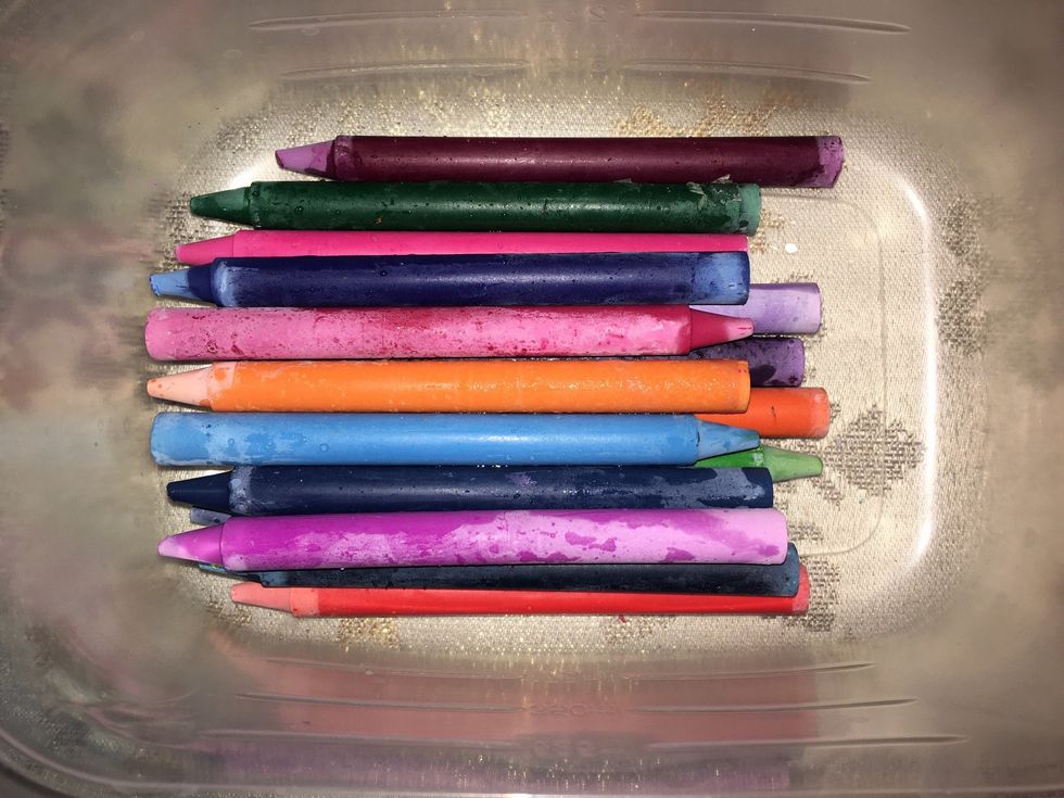 Pour out the water and remove all the wrappers from the crayons.