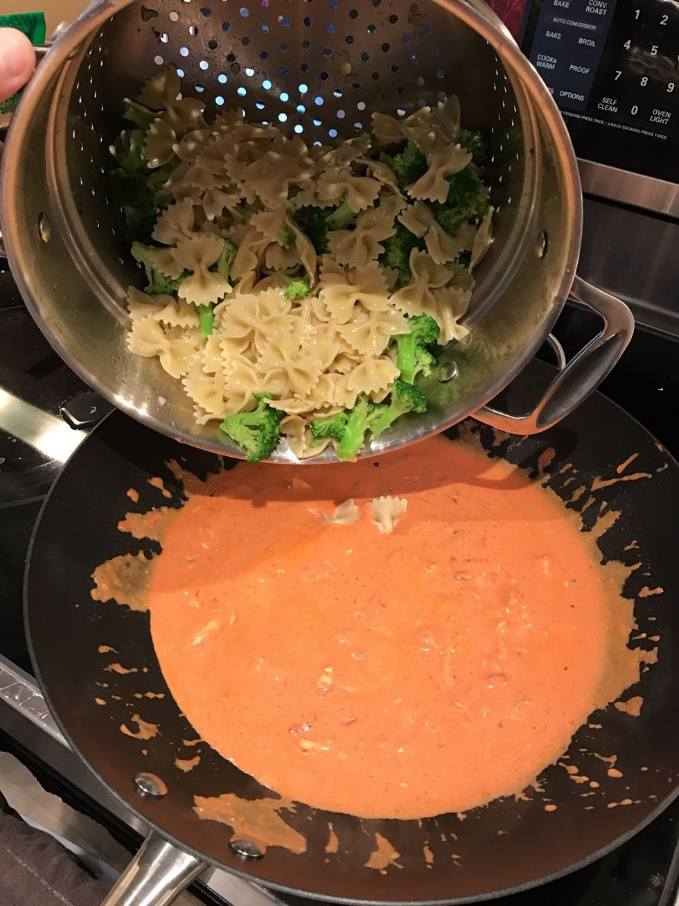 Pour pasta and broccoli into the sauce and chicken