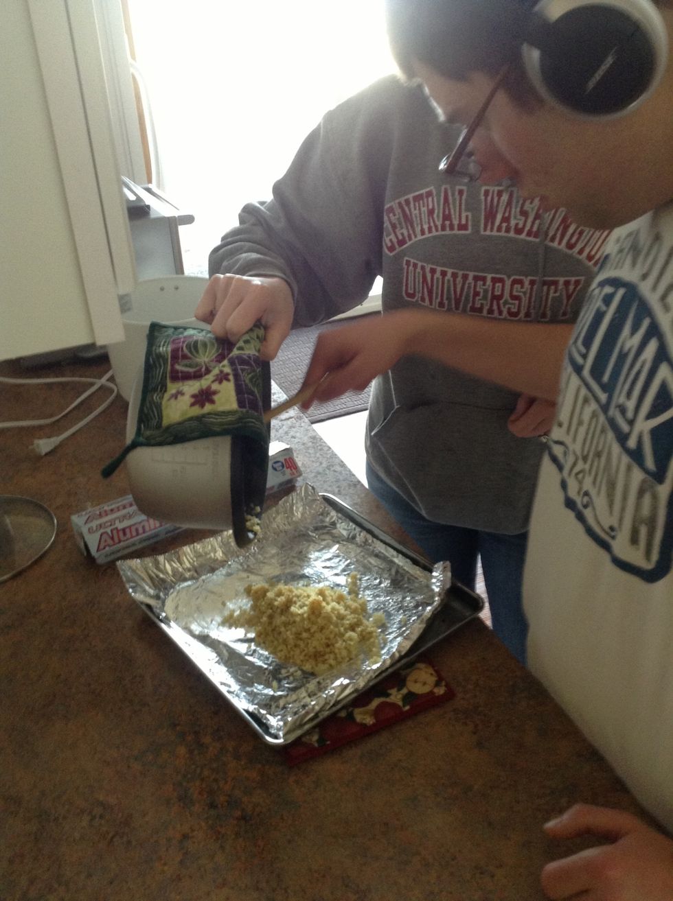 Pour quinoa onto a baking sheet lined with aluminum foil
