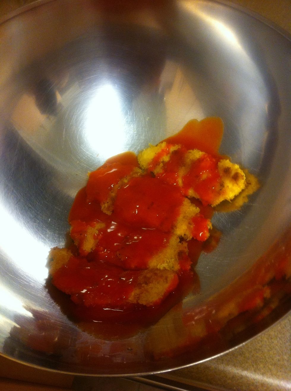 Pour red hot sauce on chicken and shake bowl around to evenly coat chicken