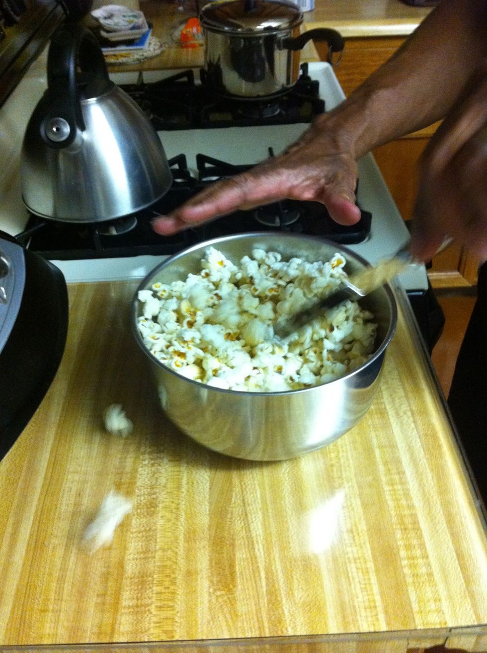 Pour salt on top. Then (I use a butter knife) mix the popcorn around to mix up the salt.