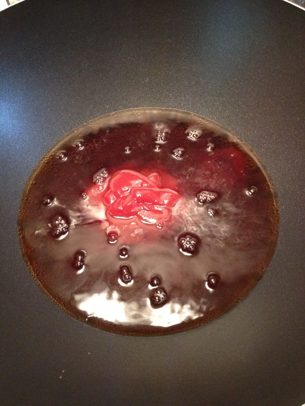 Pour soda and ketchup into wok or deep saucepan and stir.