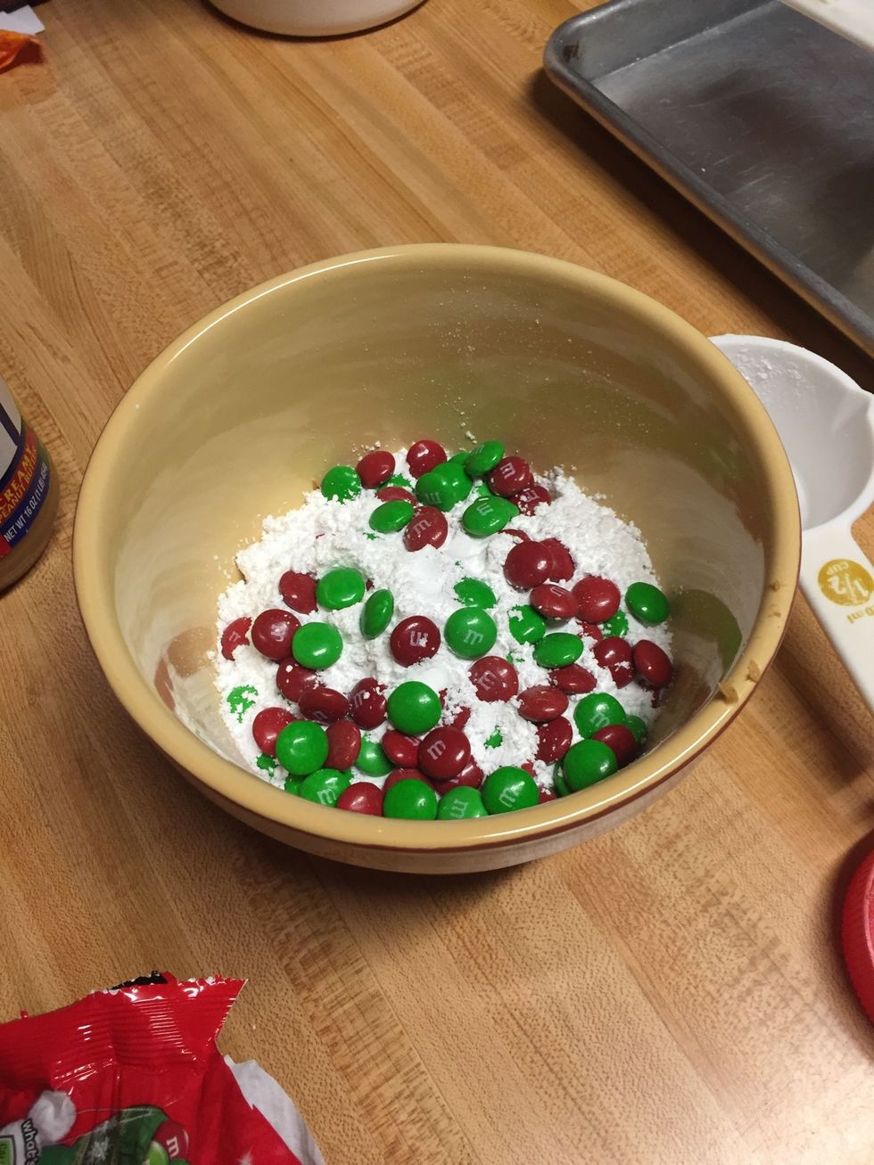 Pour some M&Ms into the bowl and stir.