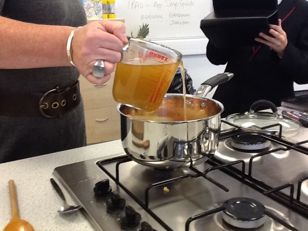 Pour stock into the vegetables in the saucepan.