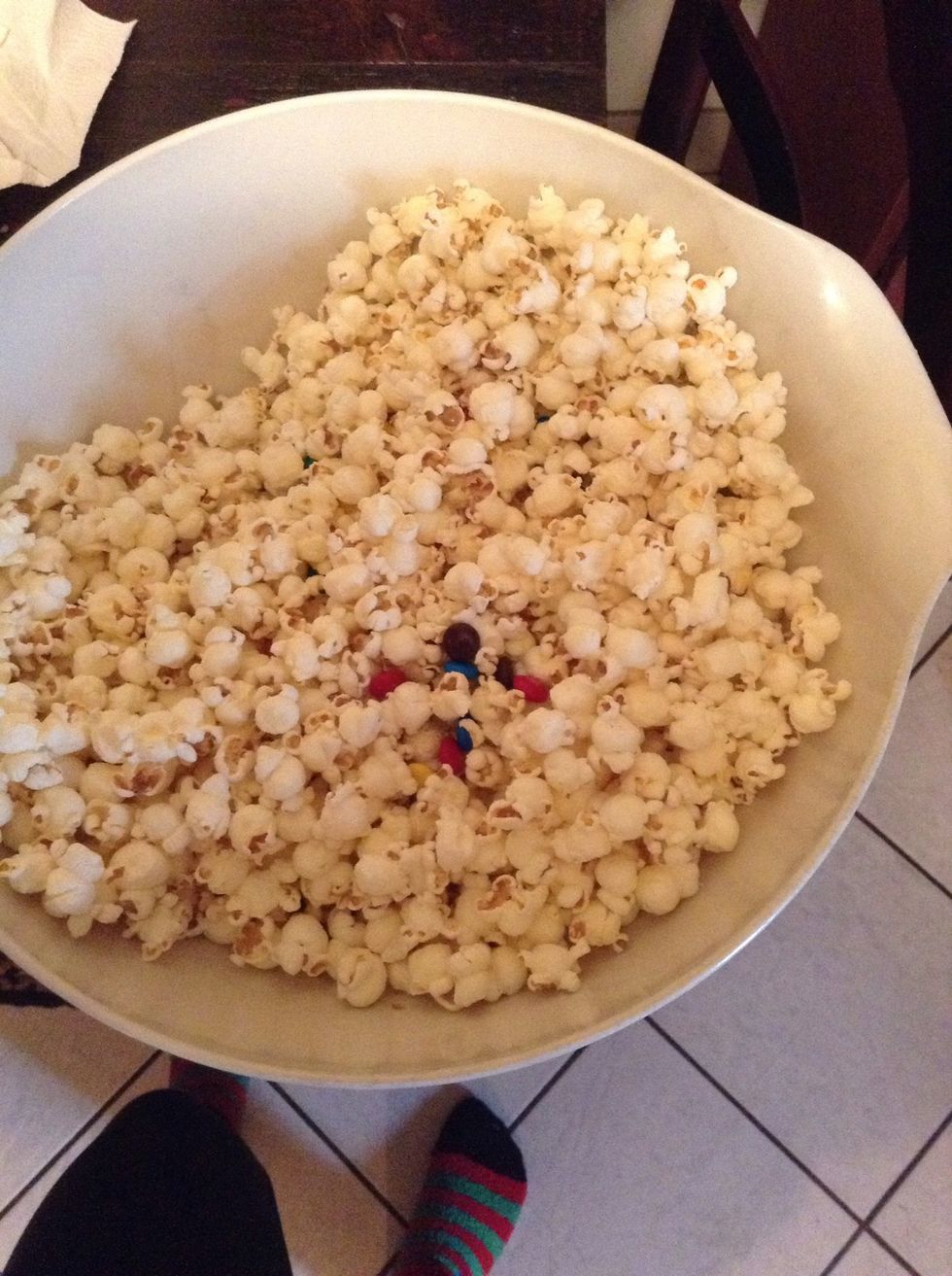 Pour the bag of popcorn and bag of M&M's into a large bowl and mix.
