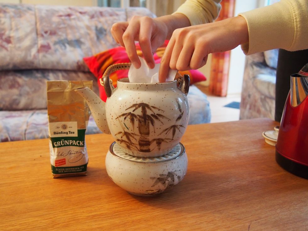 Pour the boiled water (over the filter) into the tea pot.