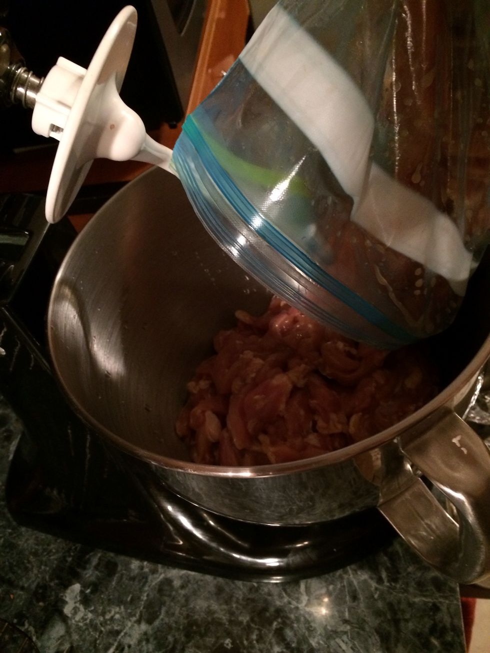 Pour the chicken in the stand mixer.