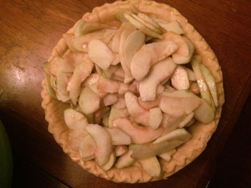 Pour the coated apples into the pre-made pie crust.