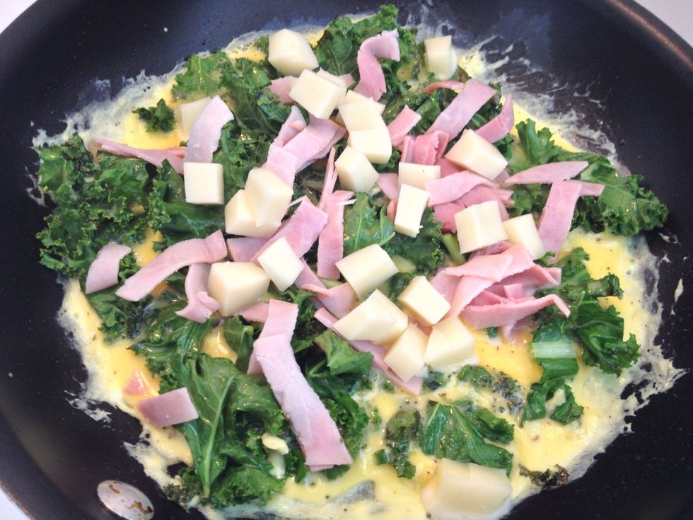 Pour the egg mixture onto the kale, stir a little, then add the cheese and ham. Cook until the egg starts to solidify and you can slide the omelet around in the pan. Don't let the eggs brown.