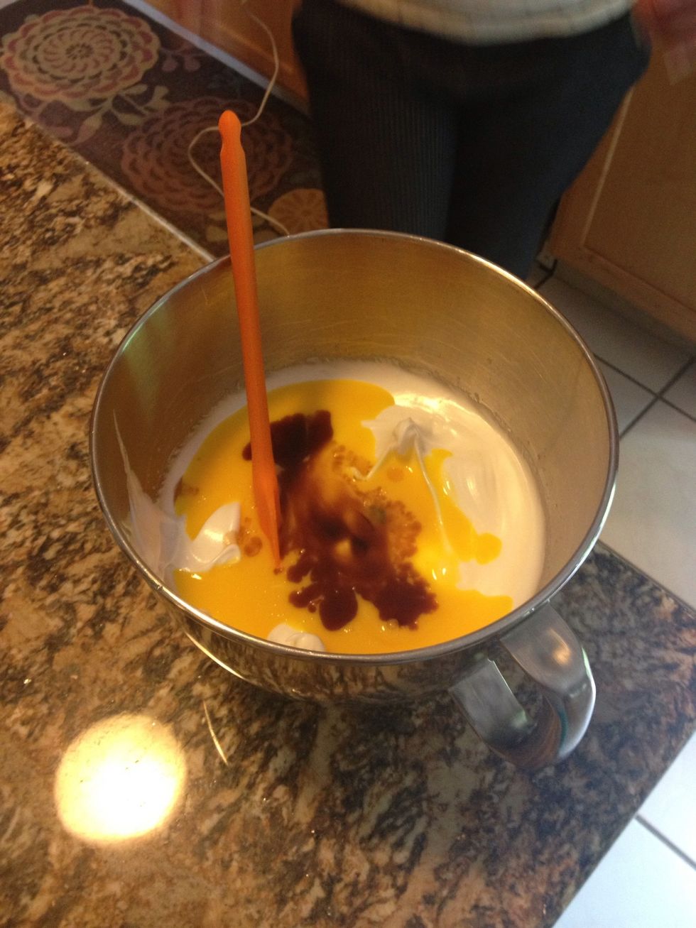 Pour the egg yokes and the vanilla into the bowl of egg whites.
