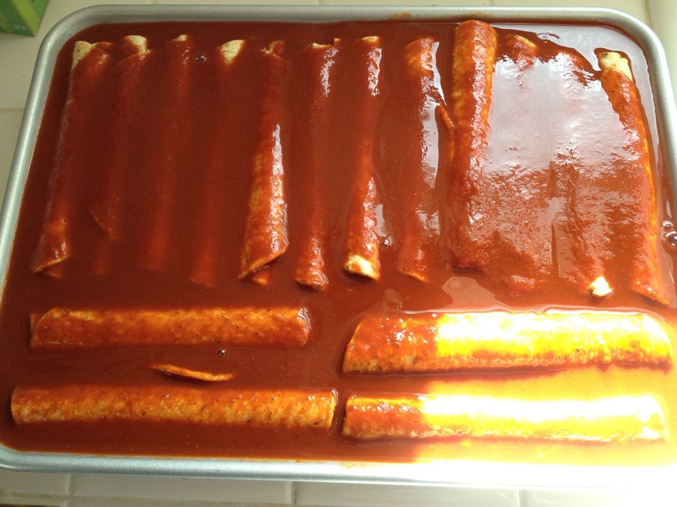 Pour the enchilada sauce over the frozen taquitos. I used the whole can, so my enchiladas will be very wet. You can add as much as you like.