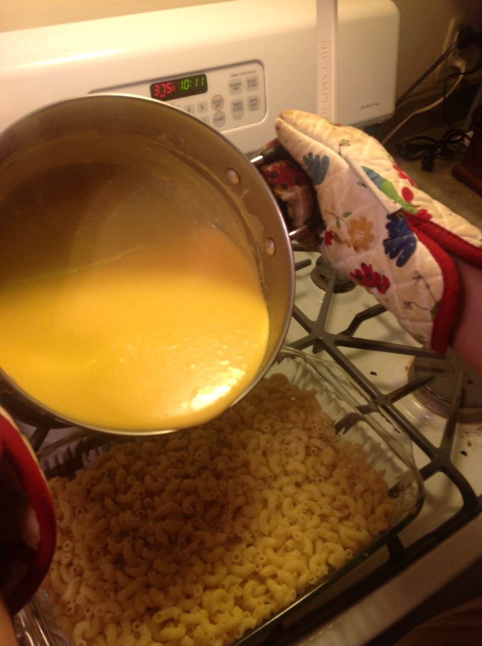 Pour the golden, cheesy sauce over the elbow macaroni.